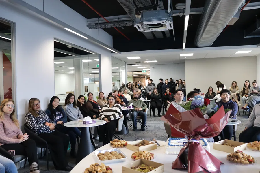 People First Healthcare staff gathered in the office for a team celebration, with catering laid out in the foreground