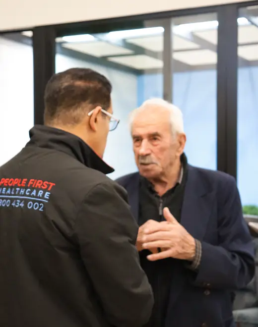 A People First Healthcare team member listening to an older man mid-conversation