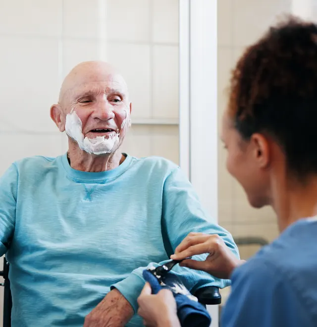 A People First Healthcare carer sharing a laugh with an older man at home