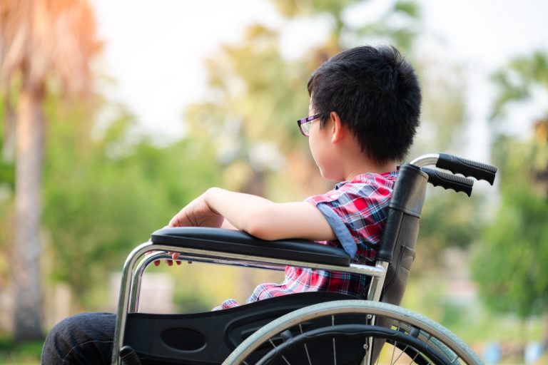 Alone young disabled man on wheelchair in the park, Patient is relaxing in garden